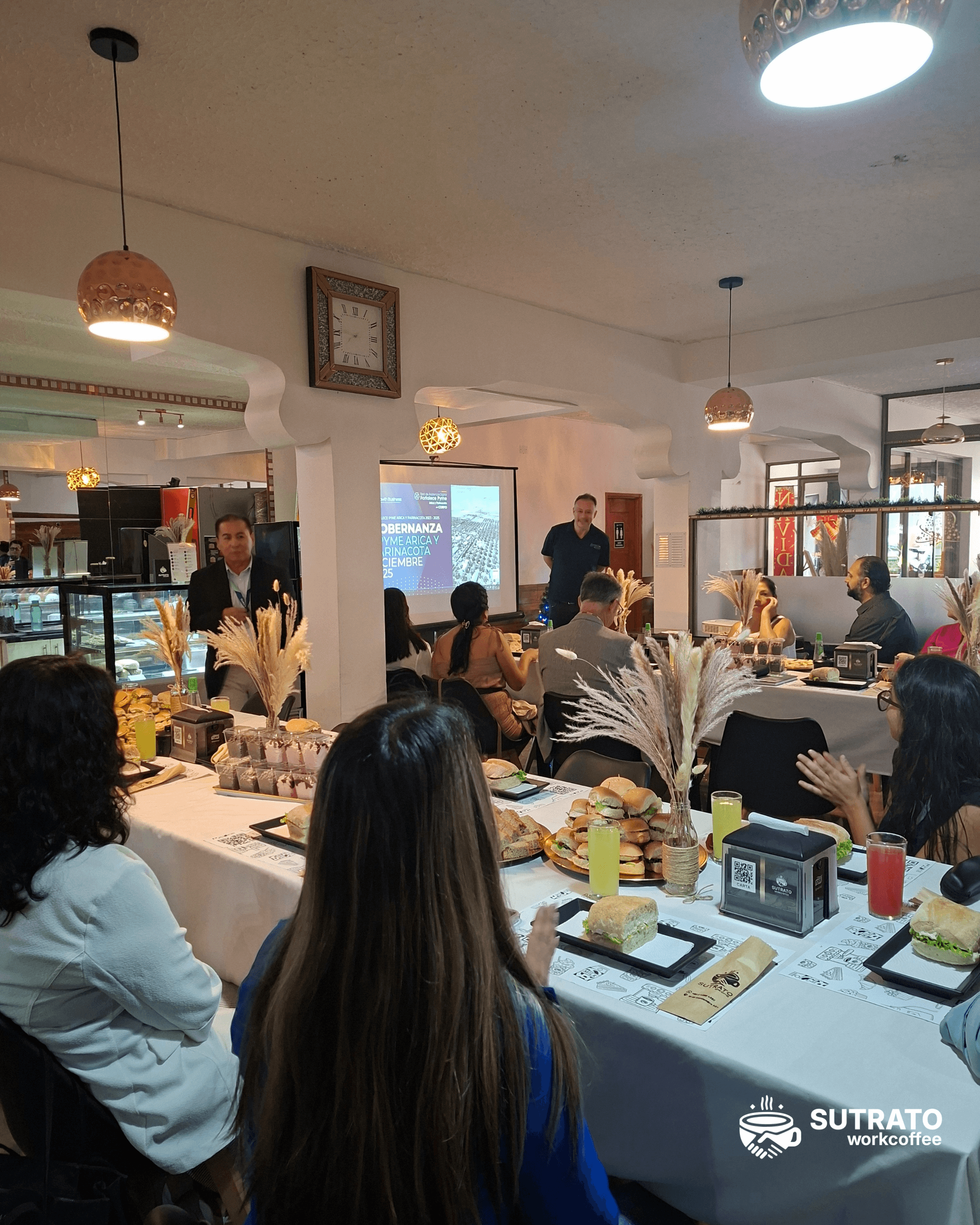 Evento realizado en Sutrato WorkCoffee con asistentes y proyección