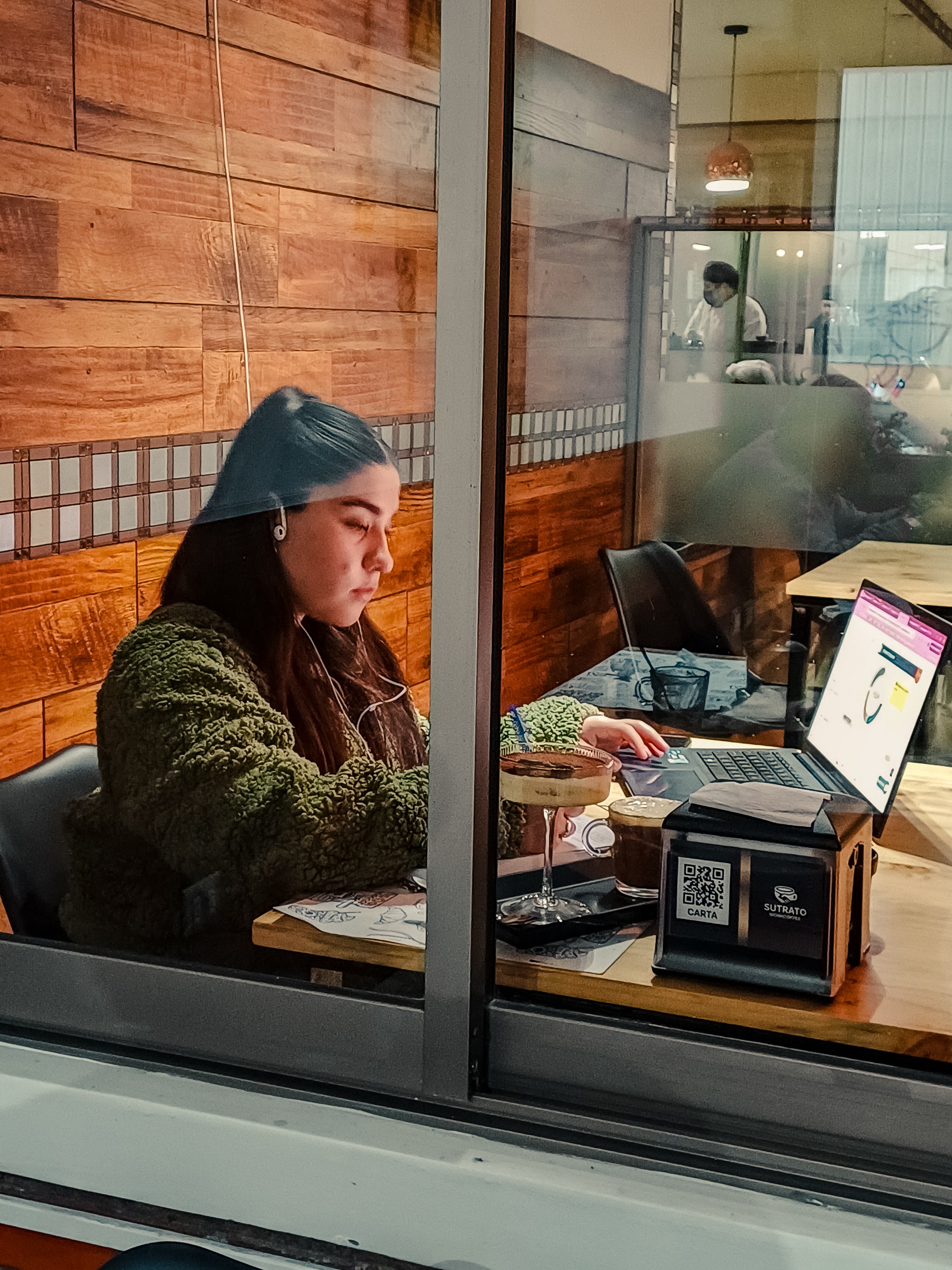 Persona trabajando en Sutrato WorkCoffee con laptop y café